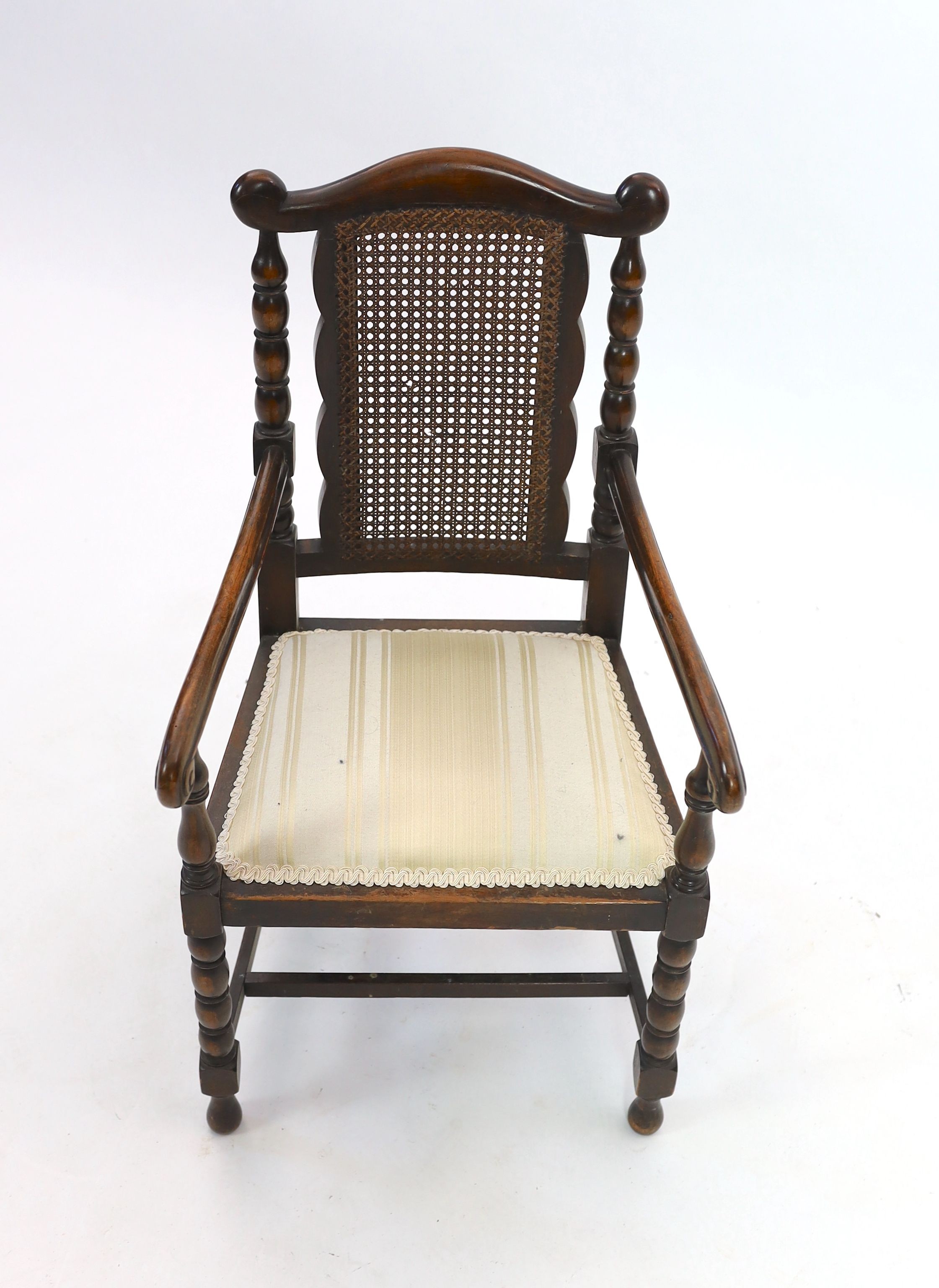 An early 20th century caned beech child's elbow chair